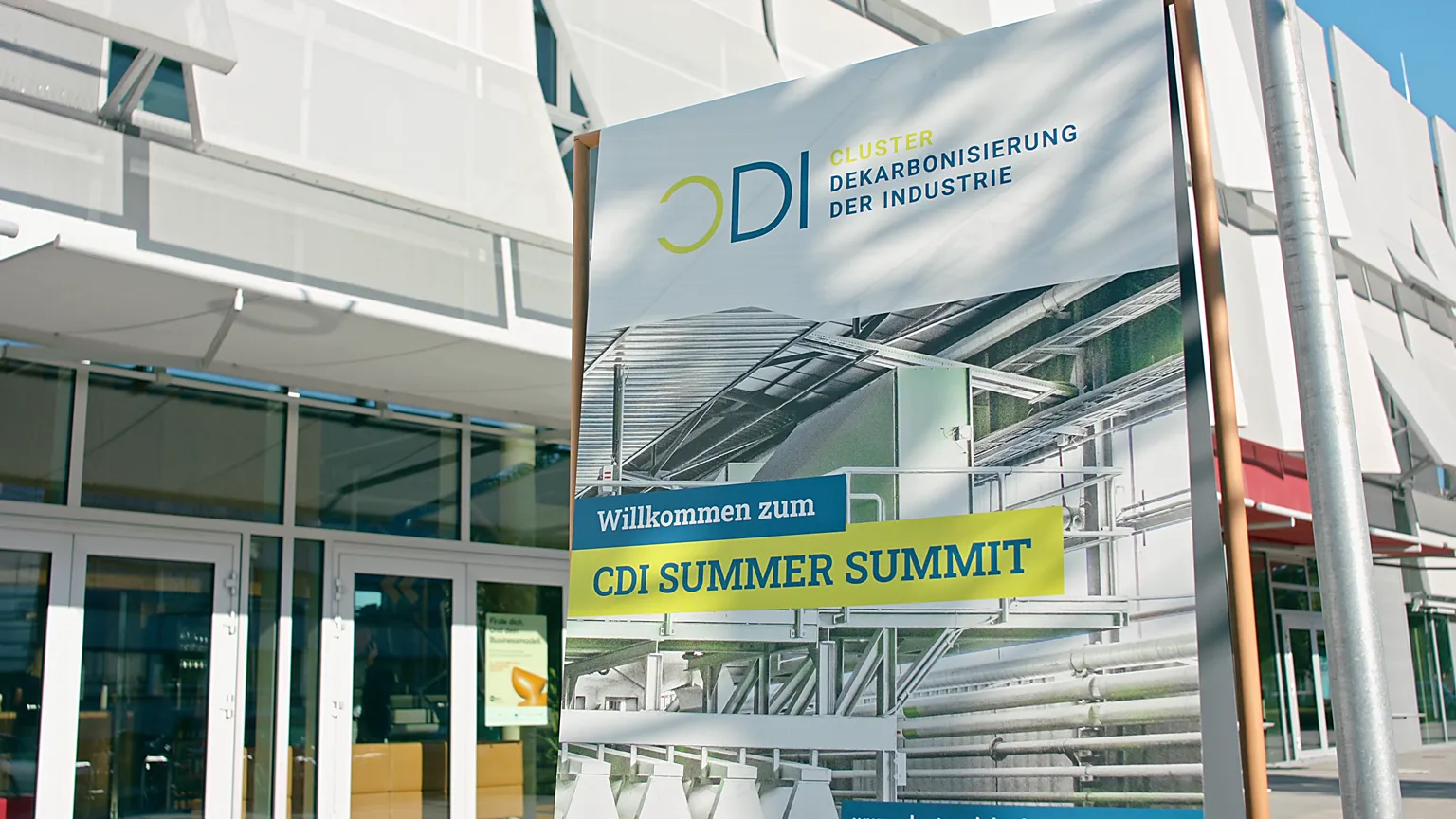 Eingang zum CDI Summer Summit mit Banner zur Dekarbonisierung der Industrie.