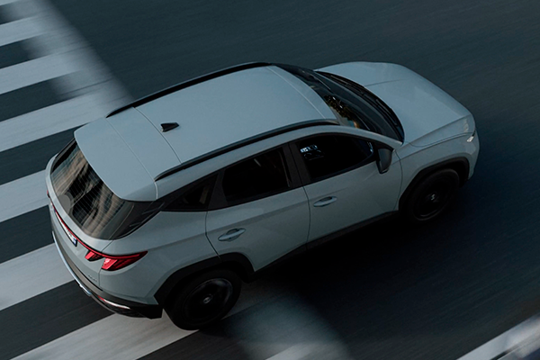 Grauer SUV fährt über Zebrastreifen – modernes Fahrzeugdesign in Bewegung.