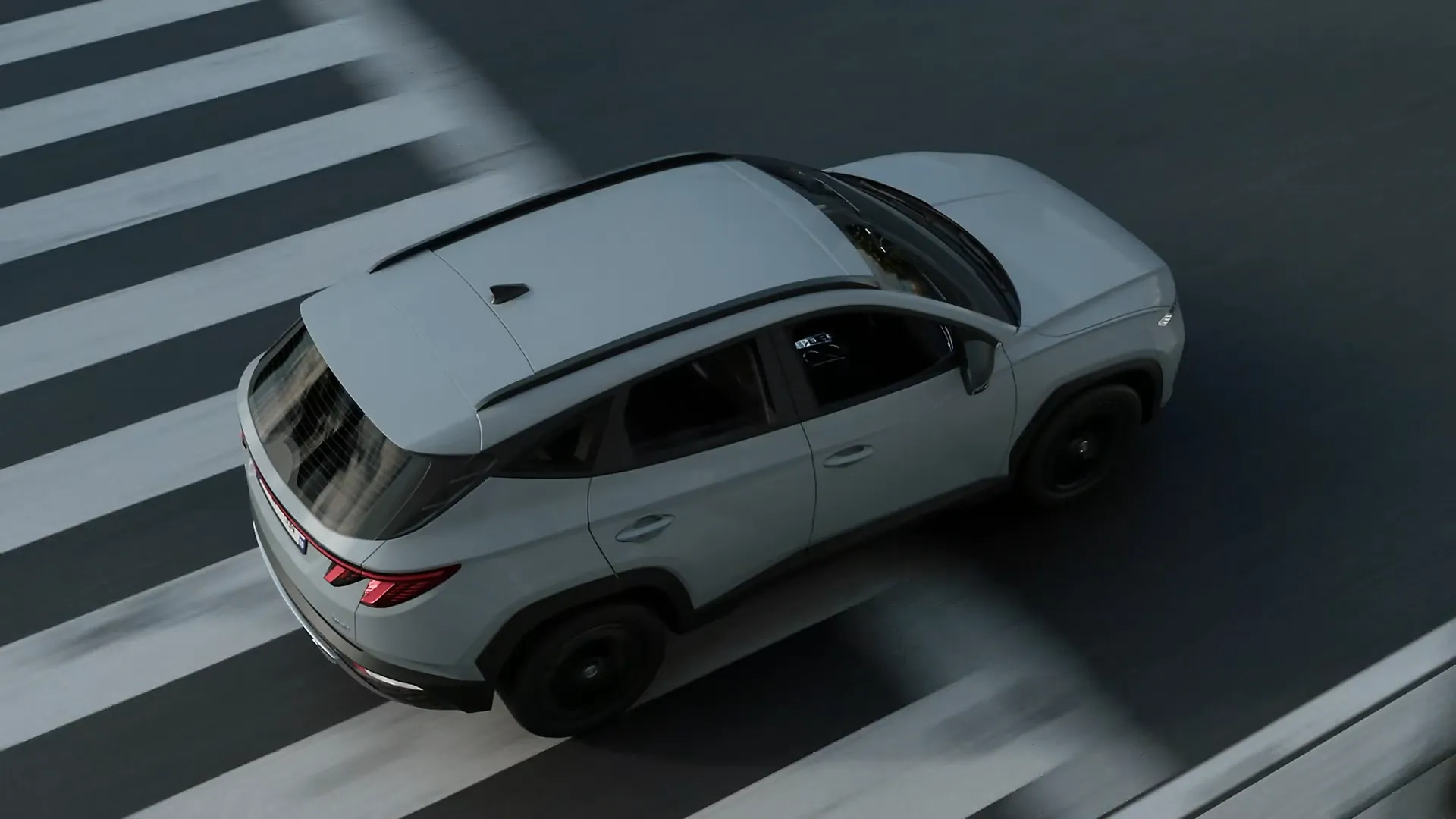 3D-animierter grauer SUV fährt über einen Zebrastreifen, dargestellt aus der Vogelperspektive. Realistische Licht- und Schatteneffekte verstärken die Tiefenwirkung der Animation.