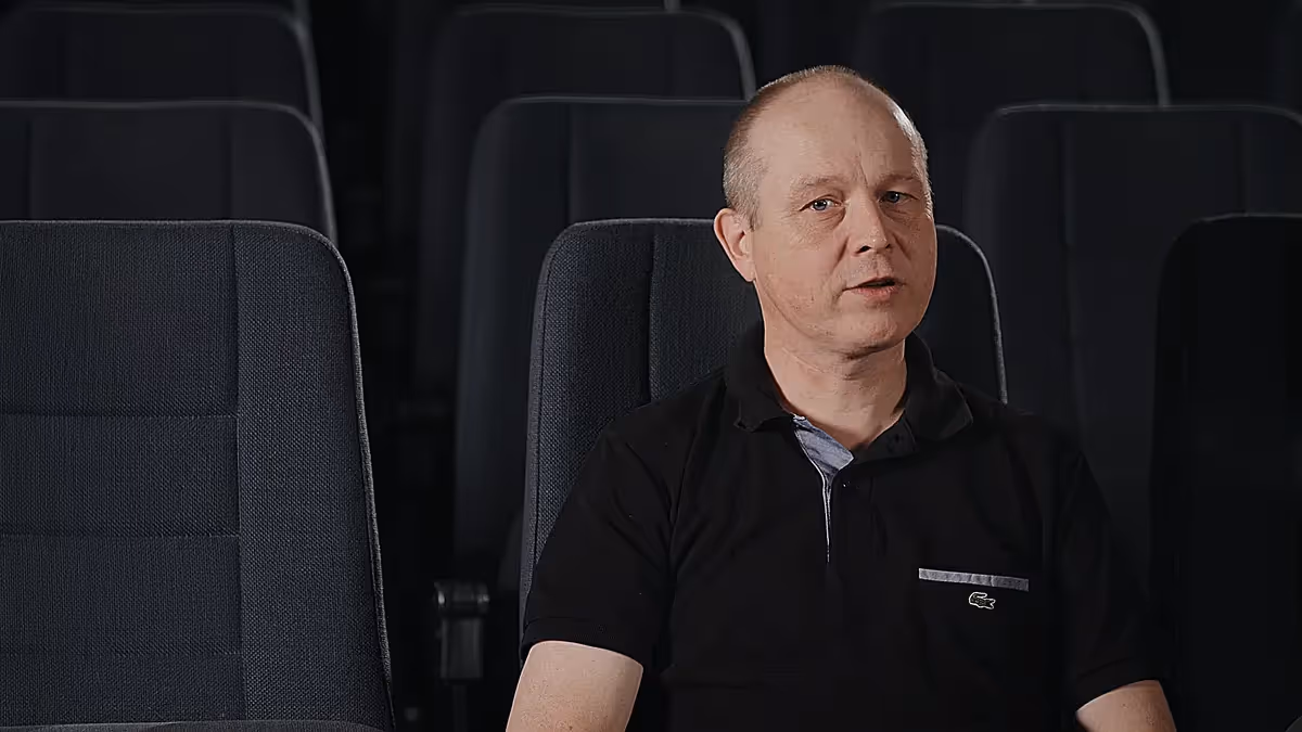 Imagefilm-Szene: Mann sitzt in einem Kinosaal und spricht vor der Kamera – professionelle Filmproduktion mit Fokus auf Interview, Storytelling und authentische Unternehmenskommunikation.