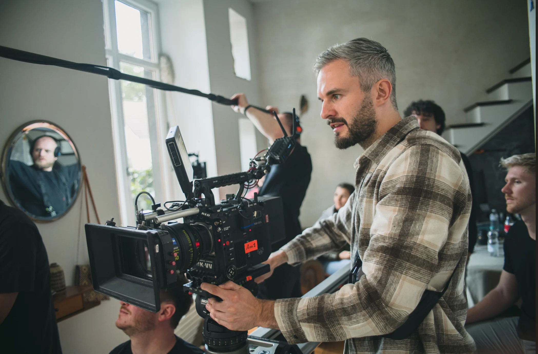 Behind the Scenes einer Imagefilm-Produktion: Kameramann am Set mit RED 8K-Kamera, Tonangel und Team