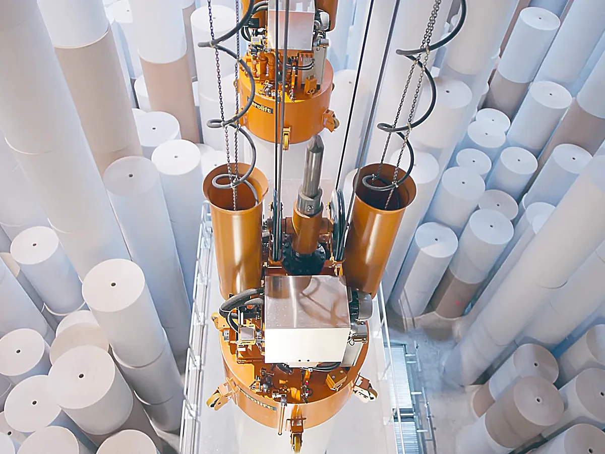 Automatisiertes Greifsystem hebt Papierrollen in einer Fabrikhalle, Szene aus dem Imagefilm für das KEI der ZUG