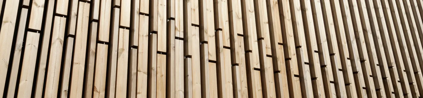 Holzverkleidung mit vertikal angeordneten hellen Holzlatten und dunklen Zwischenräumen.