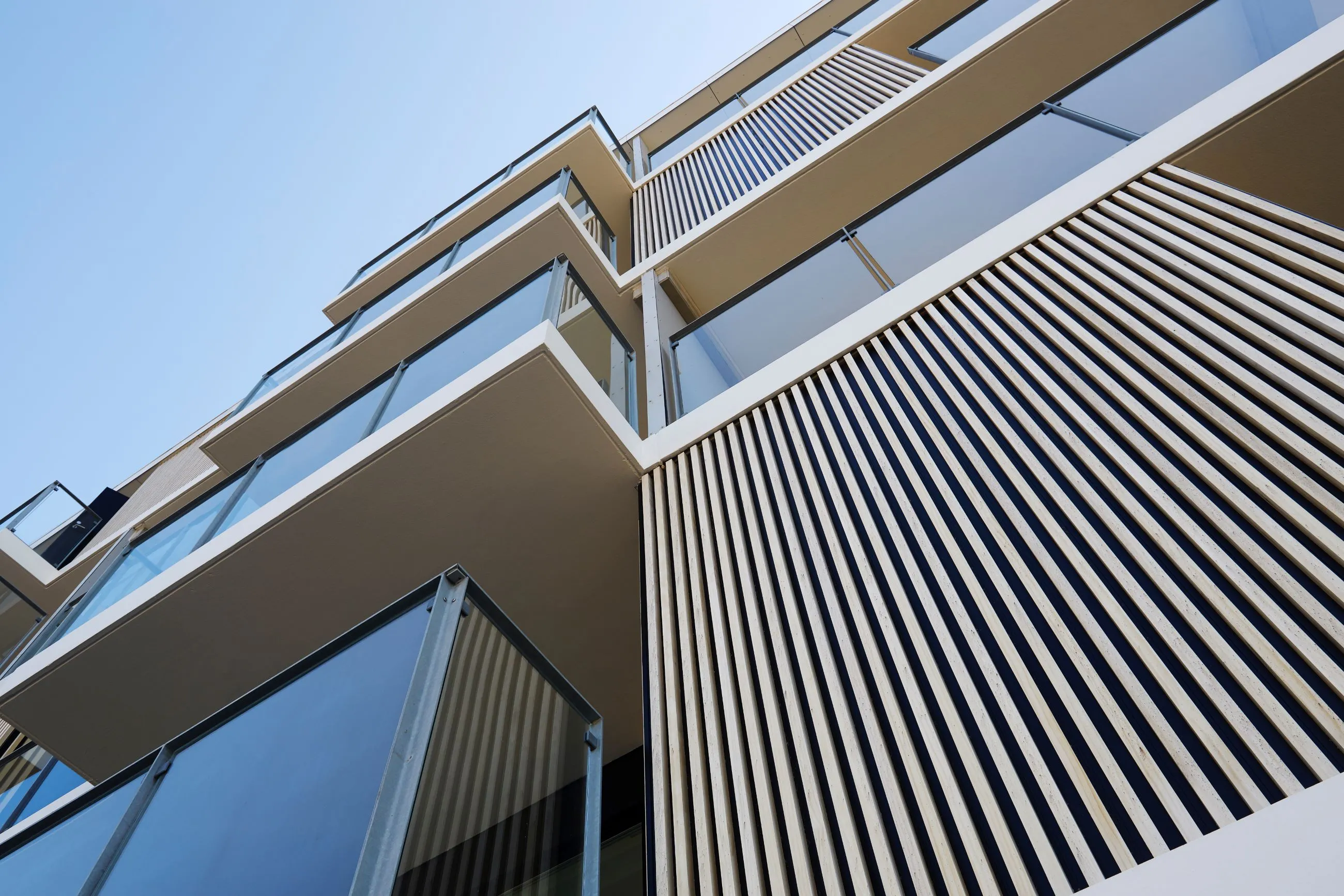 Woodfac Panel, Aluminium-Struktur: Wohngebäude mit Balkonen und vertikalen hellen Lamellen, Blick nach oben