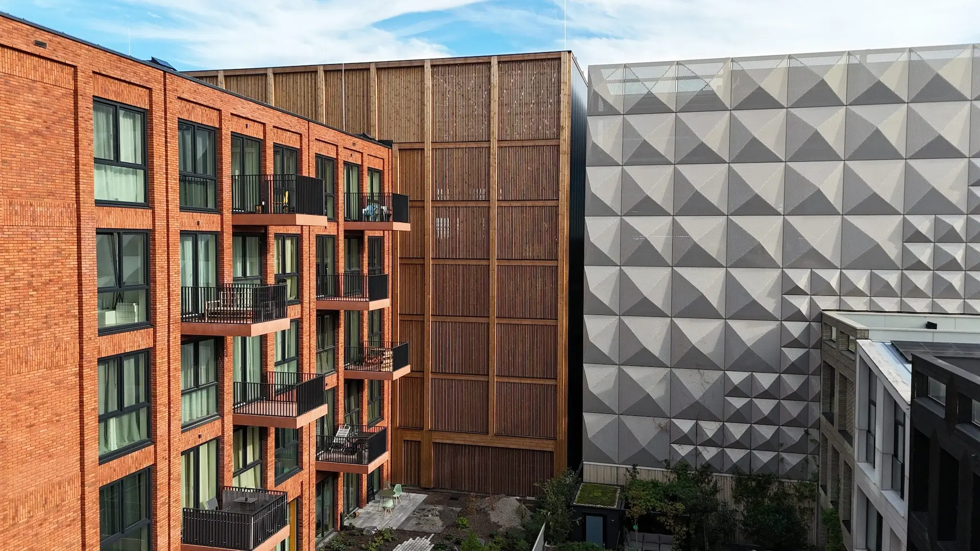 Parkhaus Distelweg in Amsterdam mit Holzlamellenfassade im Innenhof, Ansicht neben Wohngebäude