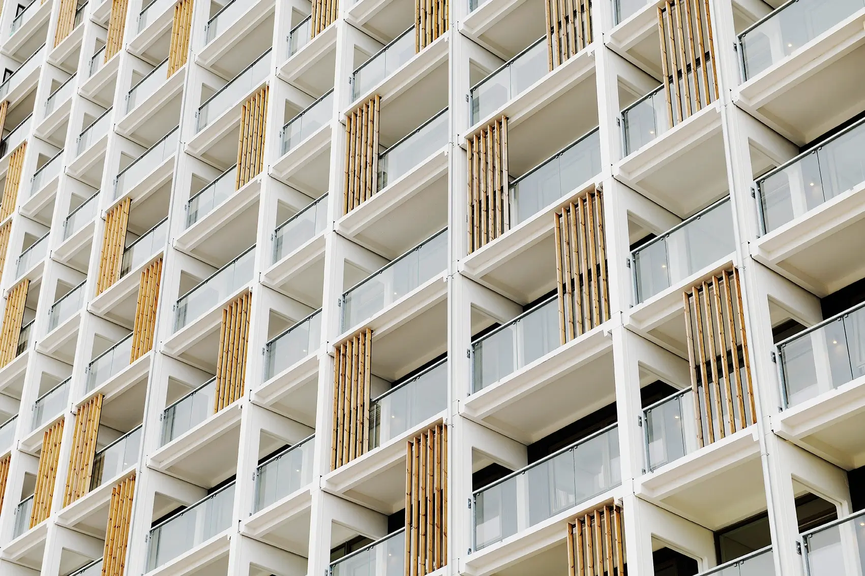 Birkeparken in Odense: Fassade mit Woodfac Click Holzlamellen an Balkonen vor weißem Gebäude