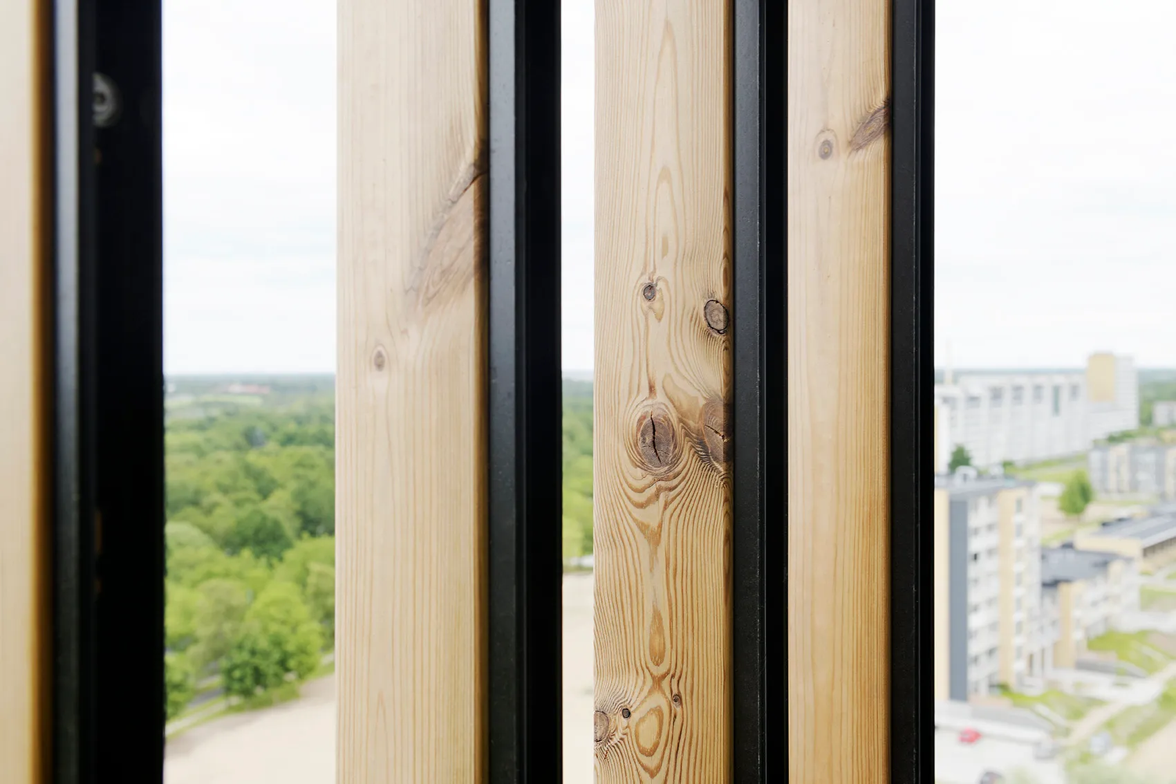 Detail der Holzlamellen von Woodfac Click mit schwarzen Profilen, Birkeparken Odense, Blick über die Stadt