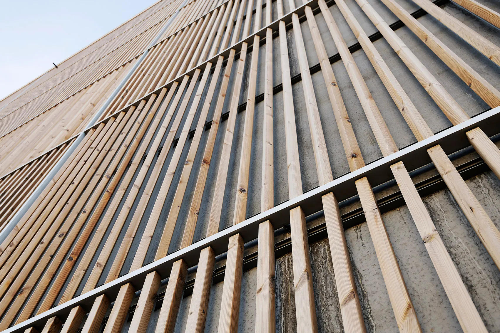Holzlamellen der Fassade Søndre Havn in der Schrägansicht, Befestigung auf Betonwand sichtbar