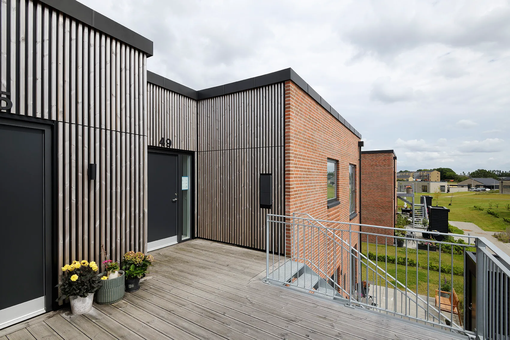 Dachterrasse im Schmetterlingspark mit senkrechten Holzlamellen, Klinker und dunklen Türen, Woodfac Panel