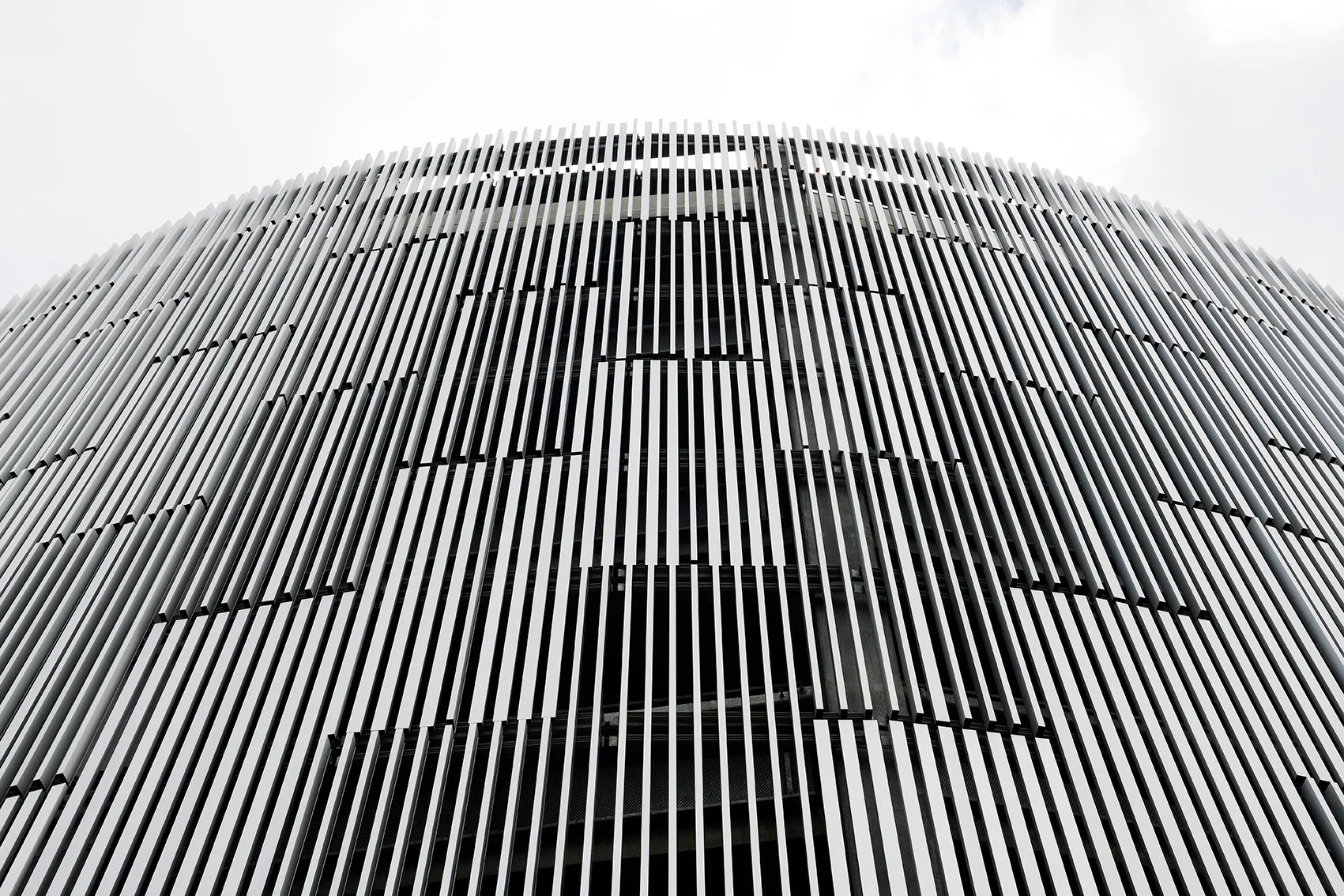 Gebogene Fassade mit vertikalen weißen Lamellen, Stigsborg, Napsu