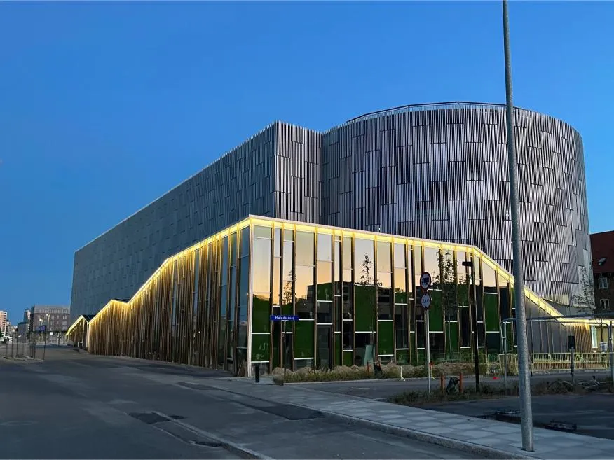 Parkhaus Stigsborg in der Abenddämmerung, beleuchtete Holzlamellenfassade mit Woodfac Click und Napsu