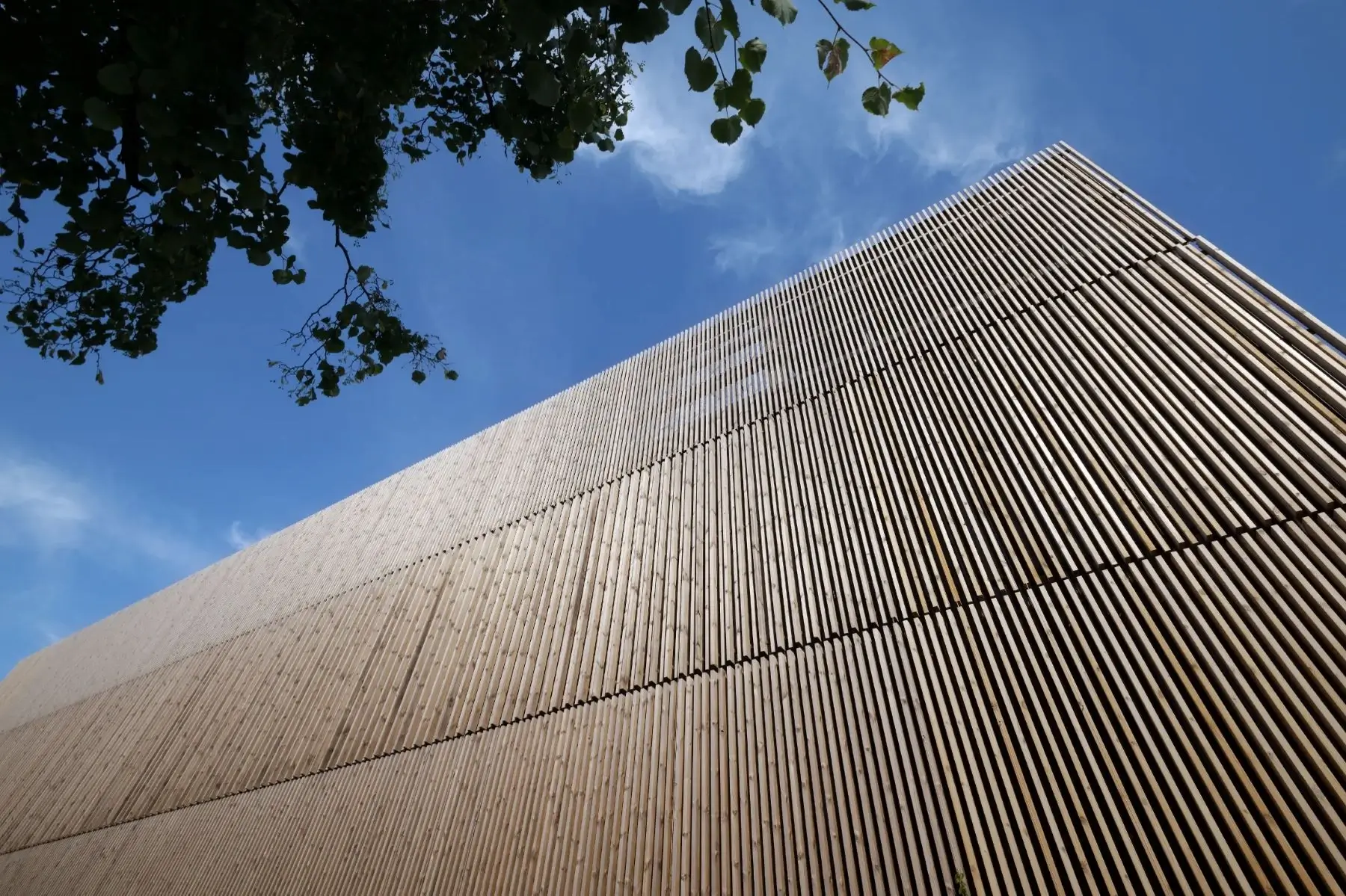 Fassade der Bella Center Ressource aus Woodfac Click Holzlamellen vor blauem Himmel