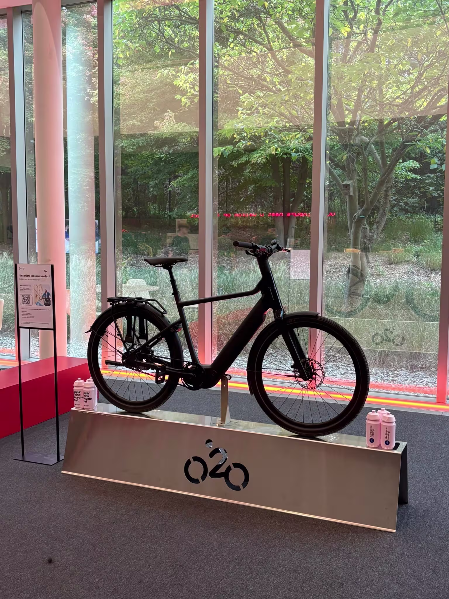 Racefiets op een o2o-display met infobord over fietsleasing