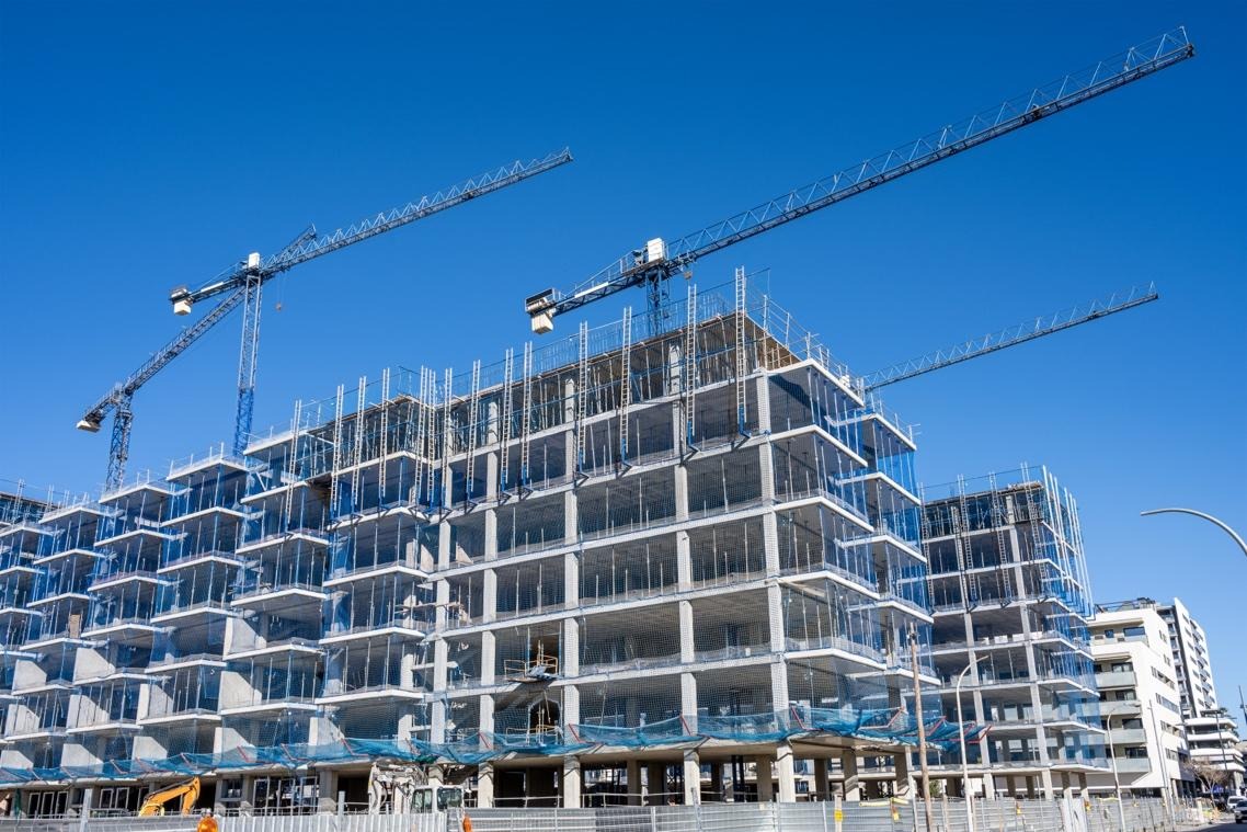 Cranes operating over large building project.