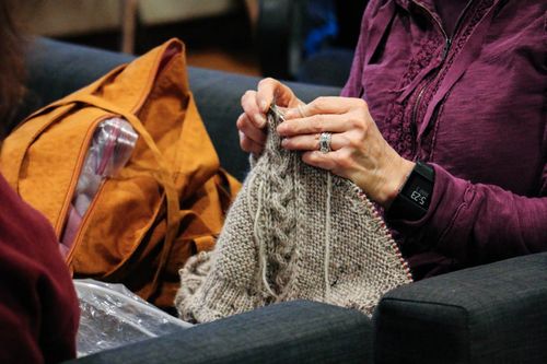 Close up of a woman's hands knitting a sweater.