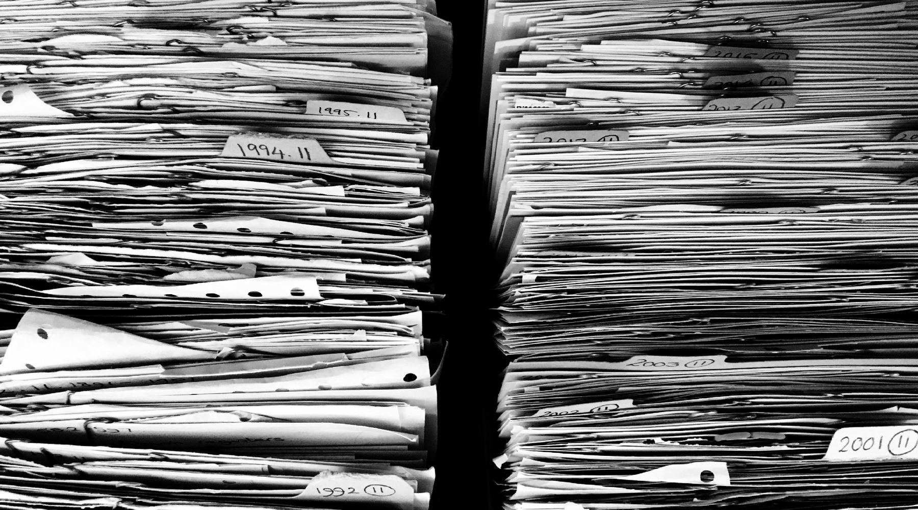 Stosy archiwalnych dokumentów z przekładkami oznaczonymi latami