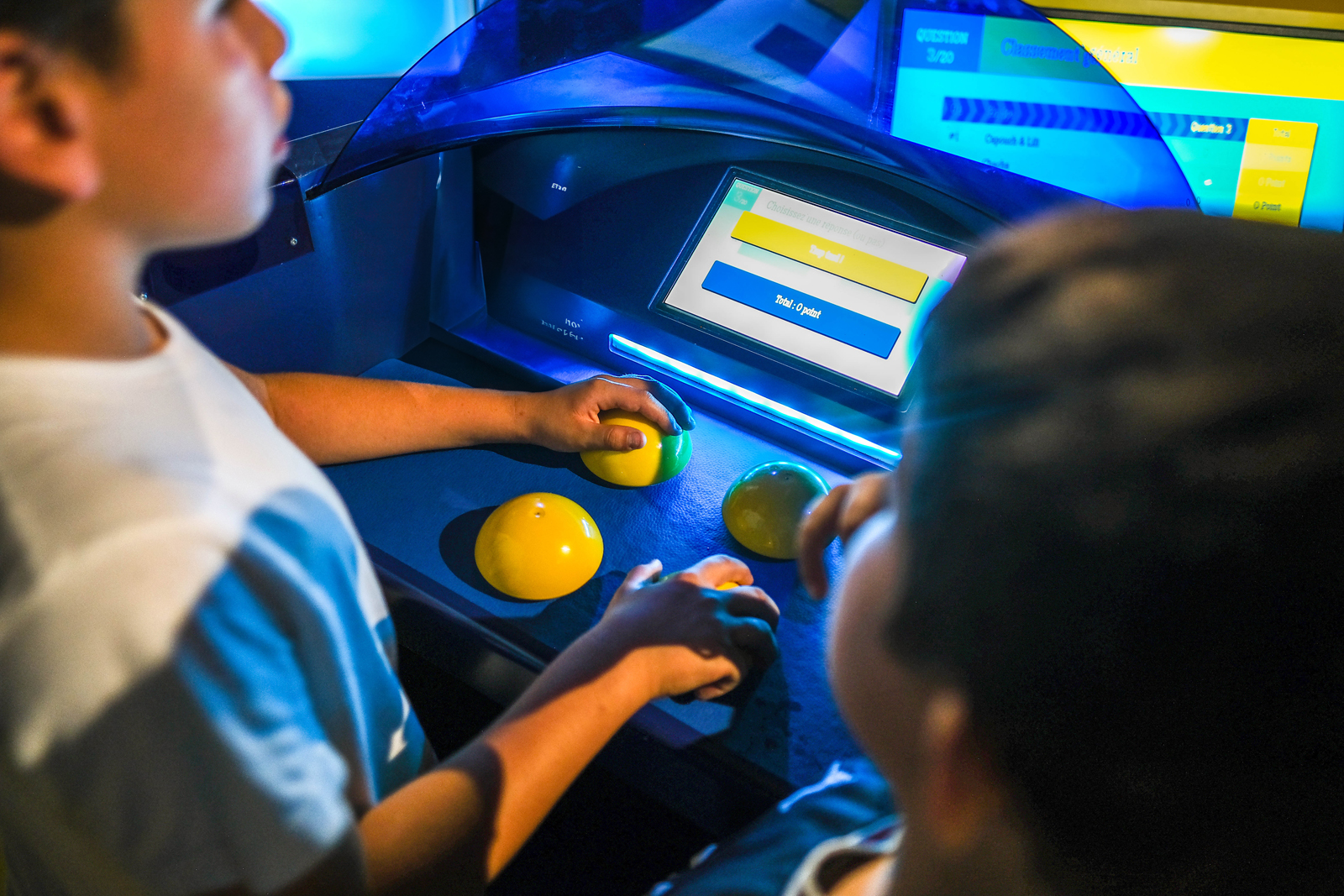 Image: Kids buzzing in a game-show-style room with bright lights