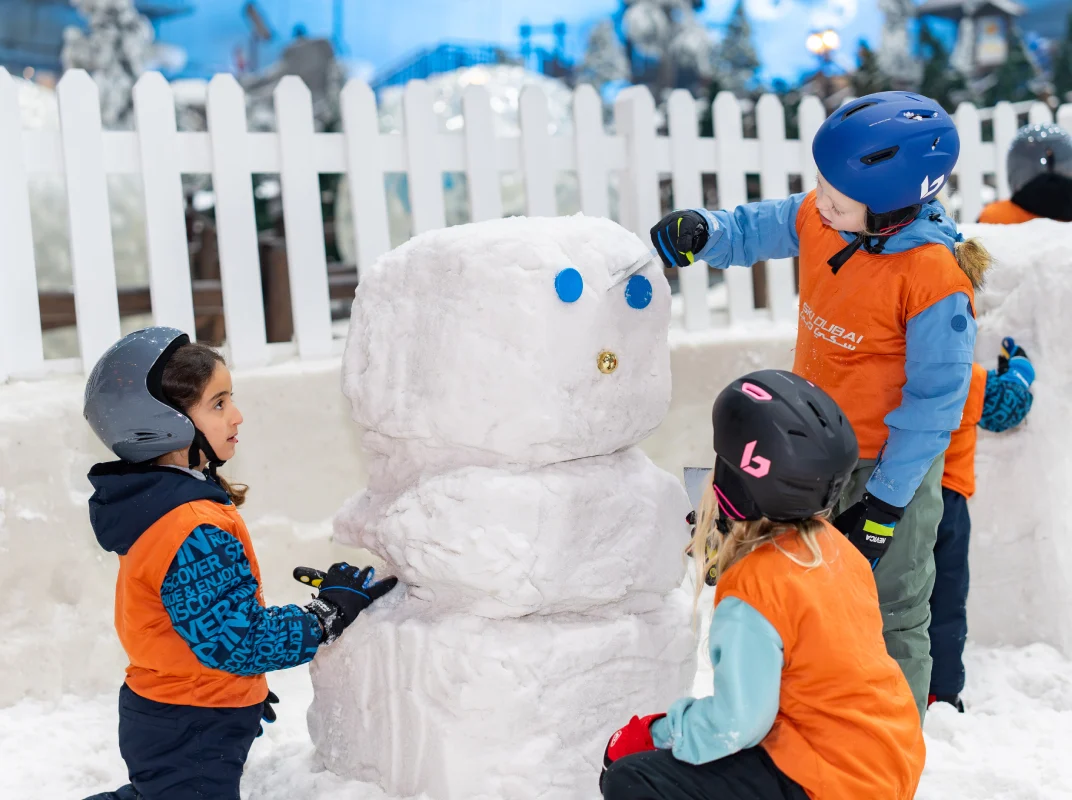 Kids in snow gear with penguins or on the slopes