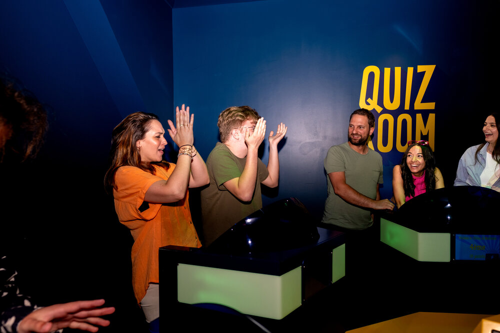 Corporate team enjoying a game show-style quiz at Quiz Room Dubai