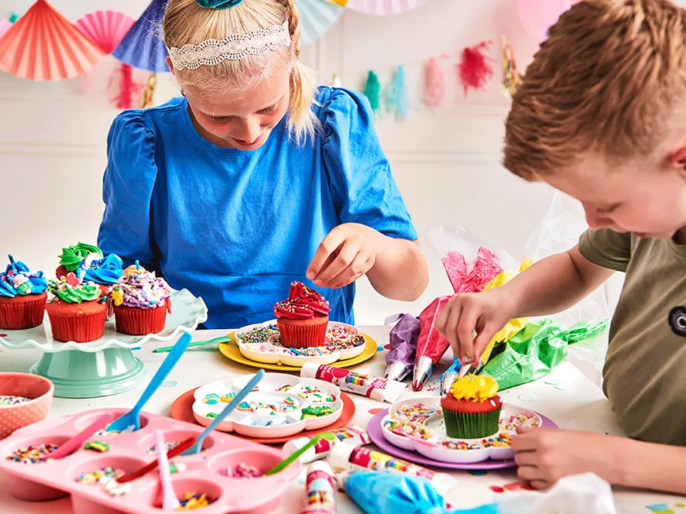 Young children decorating cupcakes during a cooking birthday class in Dubai