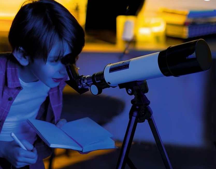 Child looking through telescope at a science-themed birthday party in Dubai