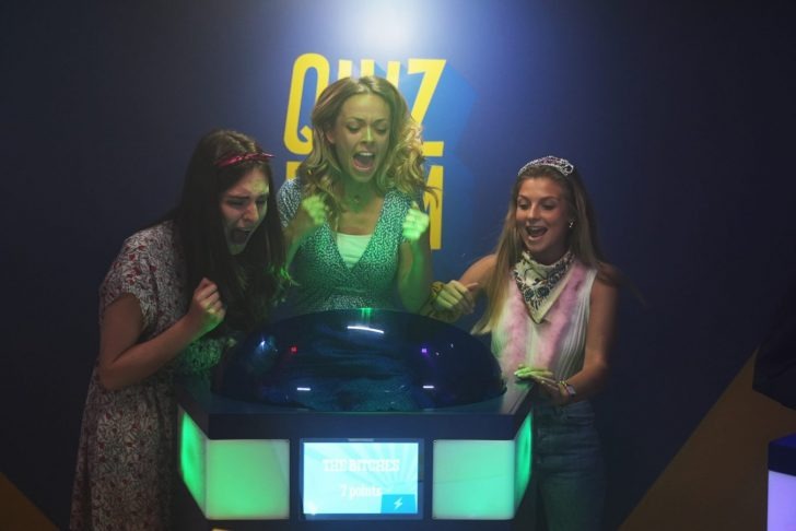 Coworkers playing a buzzer-based quiz game in a fun team-building session