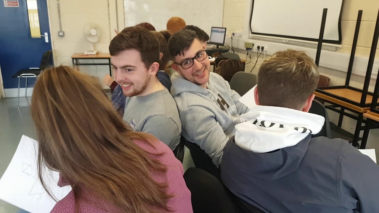 Team members drawing doodles on a whiteboard during a creative group activity