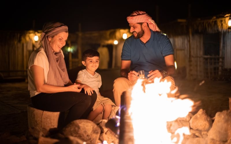 Family enjoying a desert campfire experience in Dubai during a traditional evening safari.