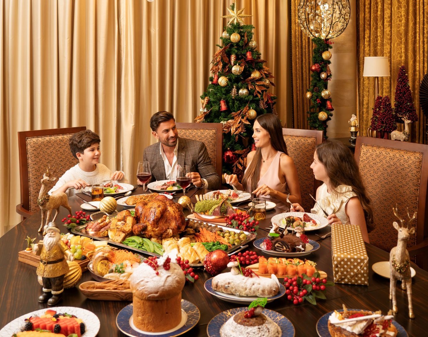 A family enjoying a festive Christmas dinner in Dubai, surrounded by holiday decorations, a Christmas tree, and a lavish spread of seasonal dishes.