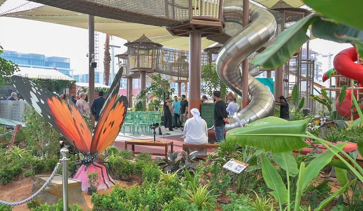 Outdoor playground in Dubai featuring giant butterfly sculptures, lush greenery, and tall spiral slides – a nature-inspired space ideal for kids’ birthday celebrations.