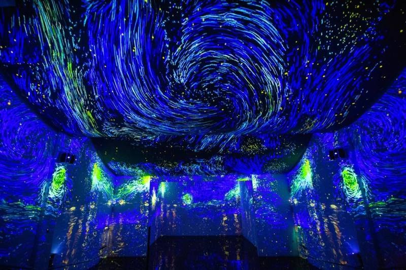 Immersive digital art installation at ToDA Dubai with swirling Van Gogh-style projections.