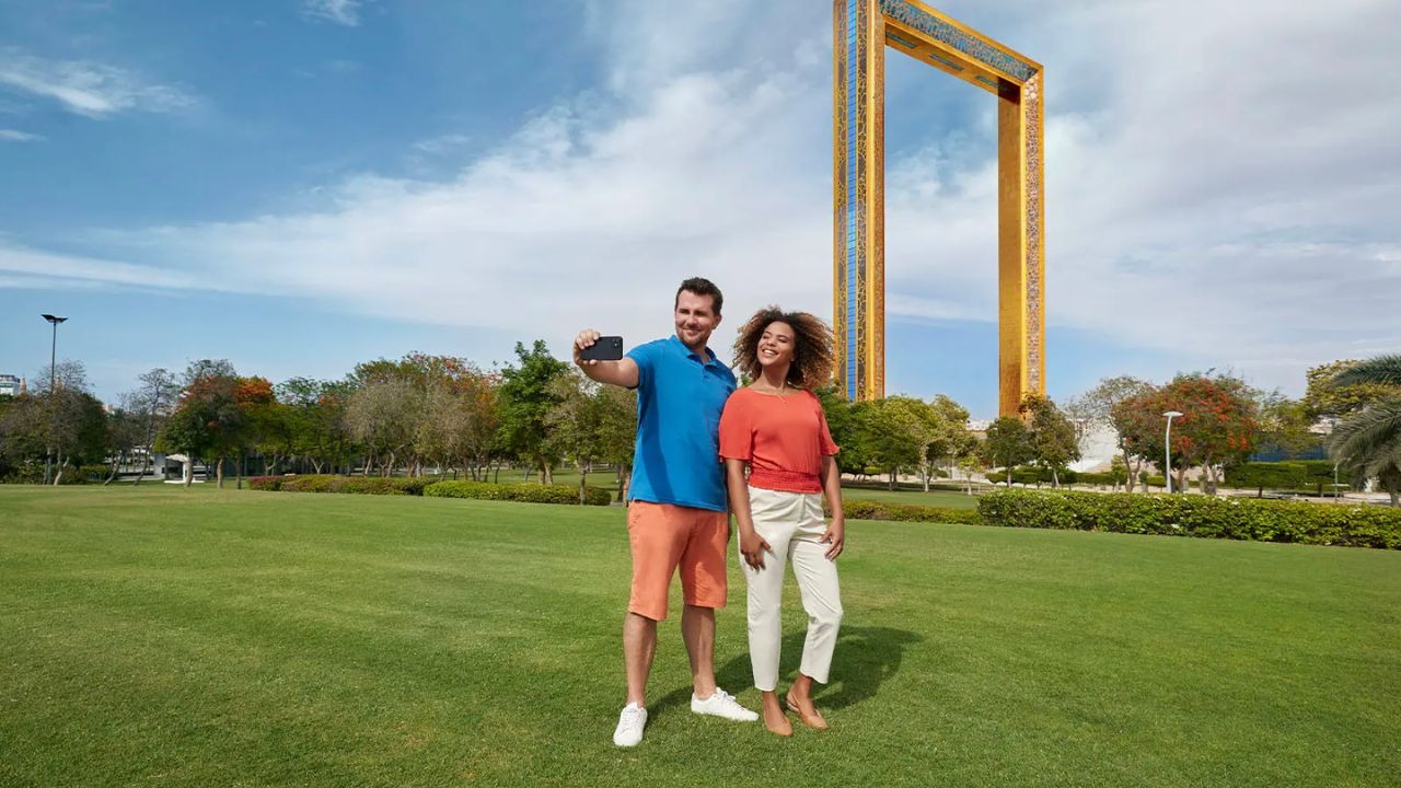 Couple taking a selfie at Dubai Frame in Zabeel Park — iconic tourist attraction offering panoramic city views and family-friendly outdoor space
