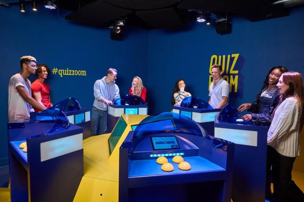 Group of coworkers engaging in a high-energy, immersive quiz game at Quiz Room Dubai for a fun team-building experience.
