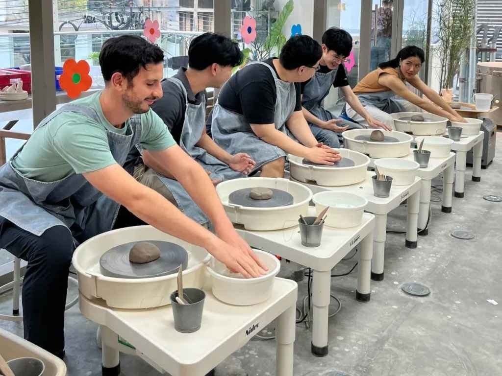 Group of colleagues creating pottery during a hands-on, creative team-building workshop in Dubai.
