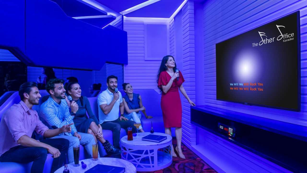 Friends singing and laughing together in a private karaoke room in Dubai.