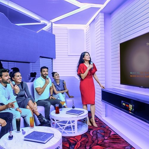 Group of friends singing in a private karaoke room in Dubai during a fun night out