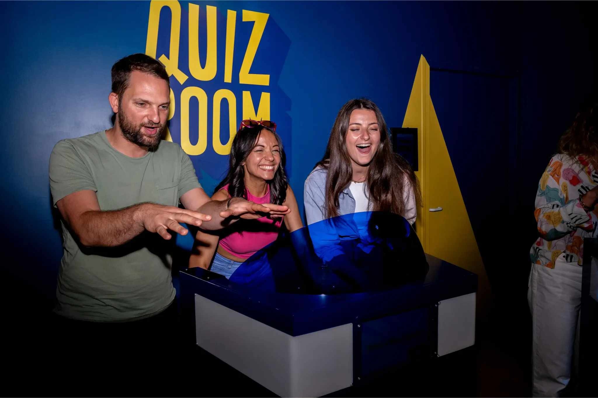  Friends enjoying a birthday group activity at Quiz Room Dubai, laughing and playing an interactive quiz game.