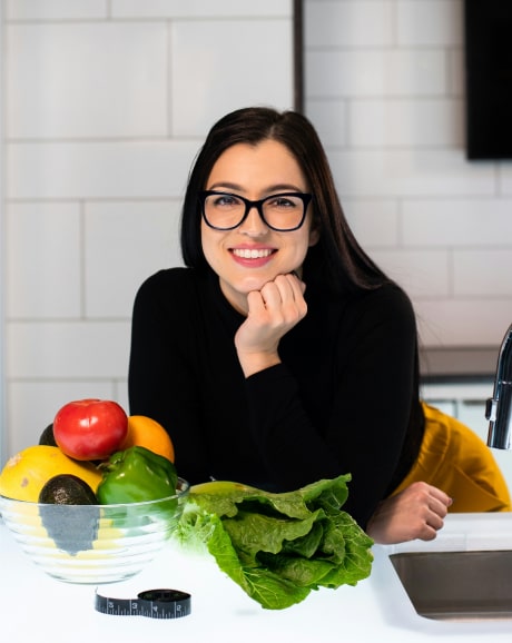 Girl with a bowl of fresh vegetables in the kitchen