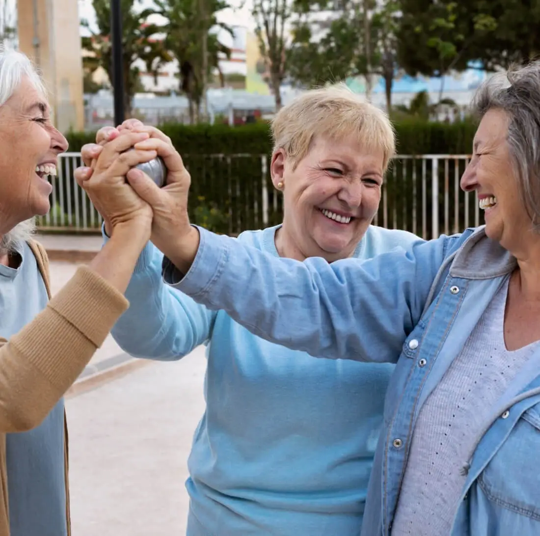 Three smiling older women celebrating together