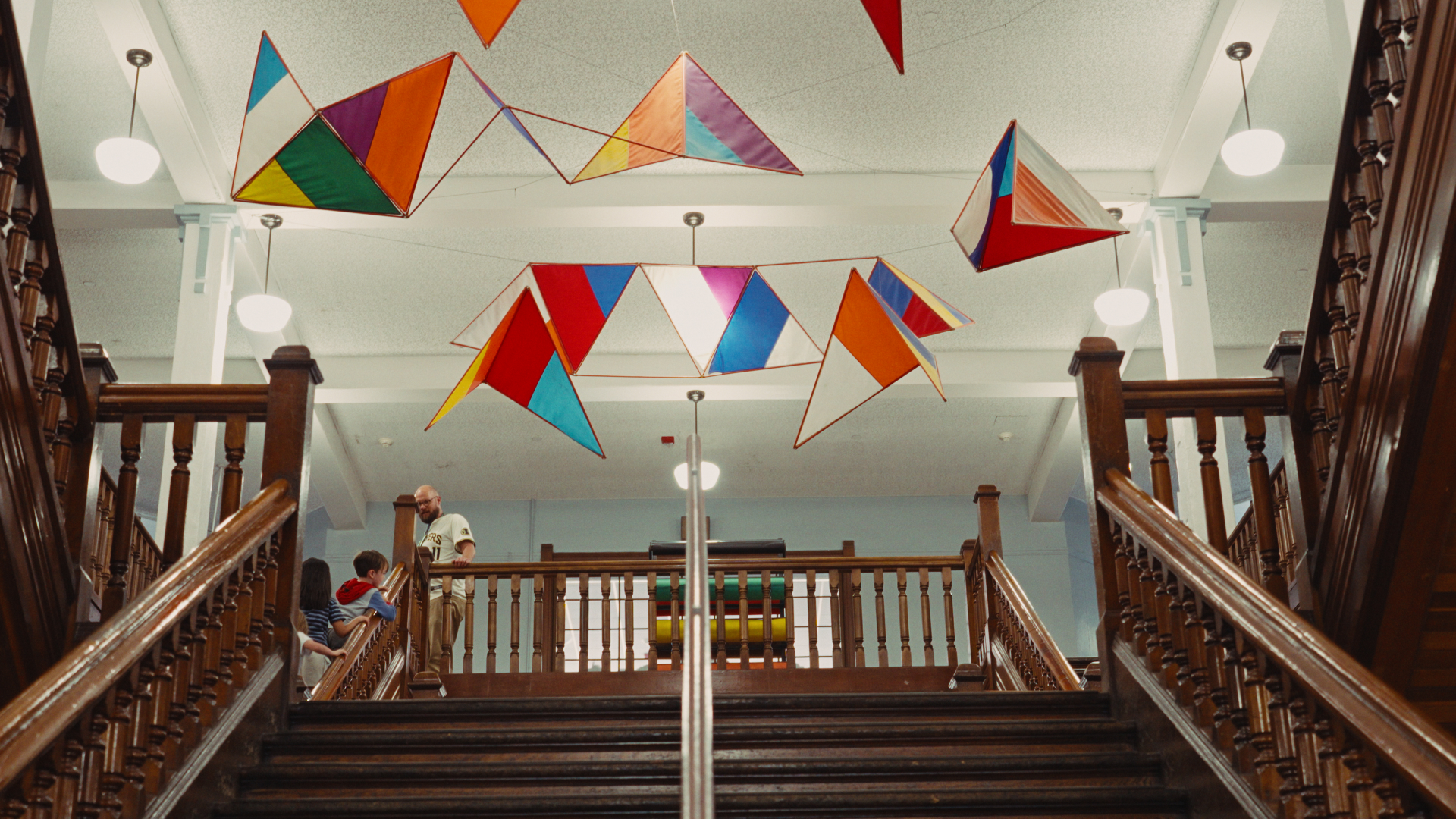 Paper kites hanging above a school staircase