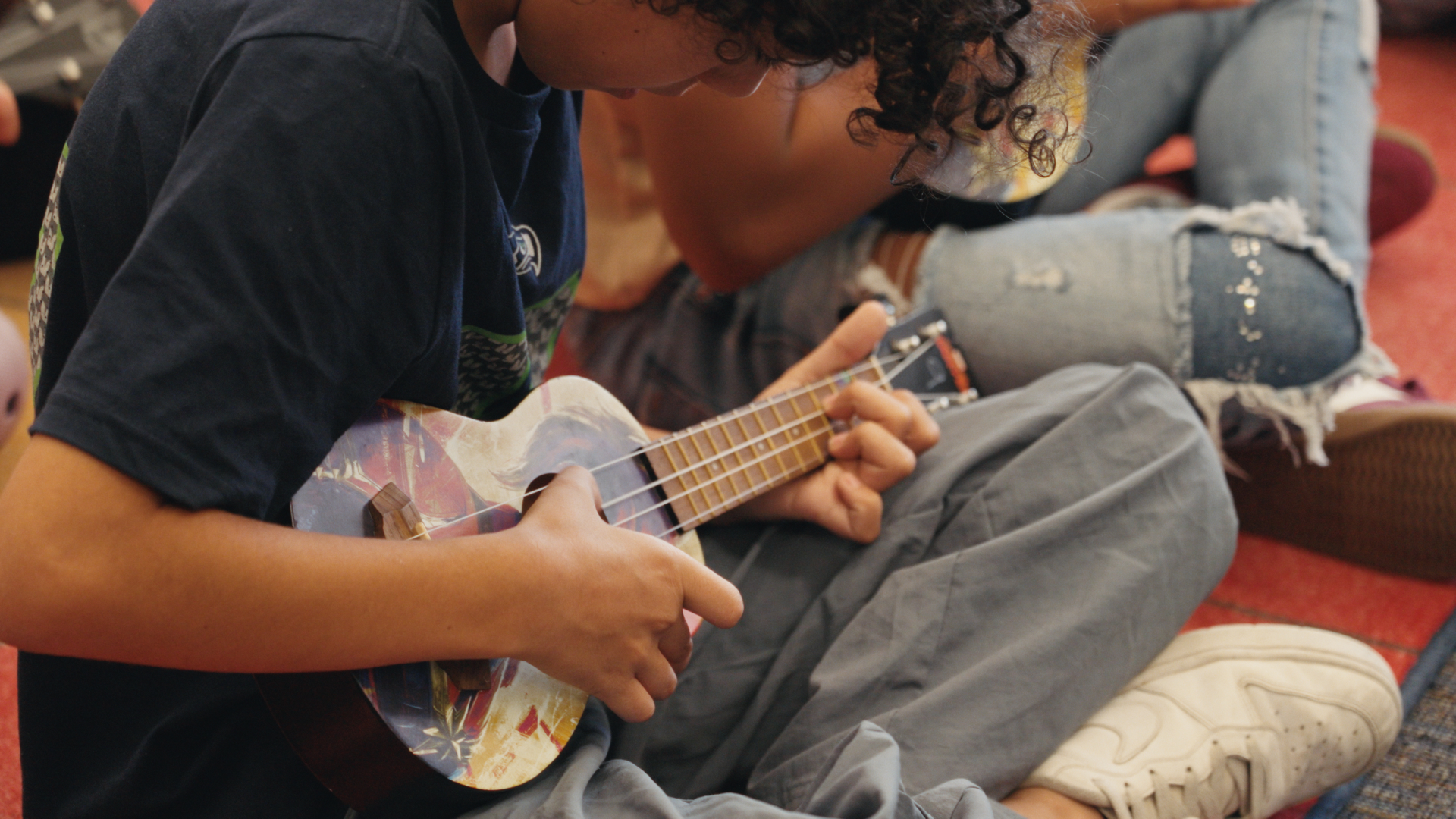 A student playing ukulele in a music class