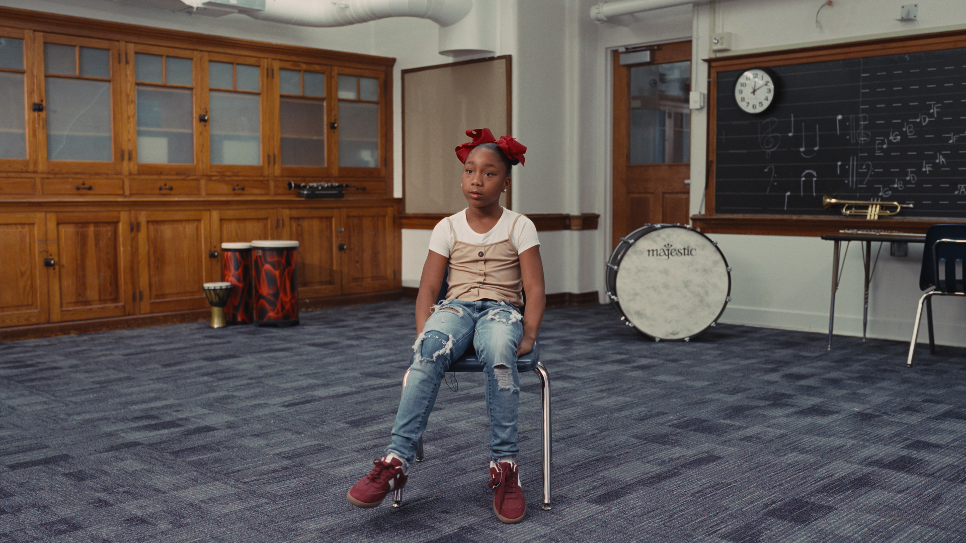 A student sitting on a chair in a school music room