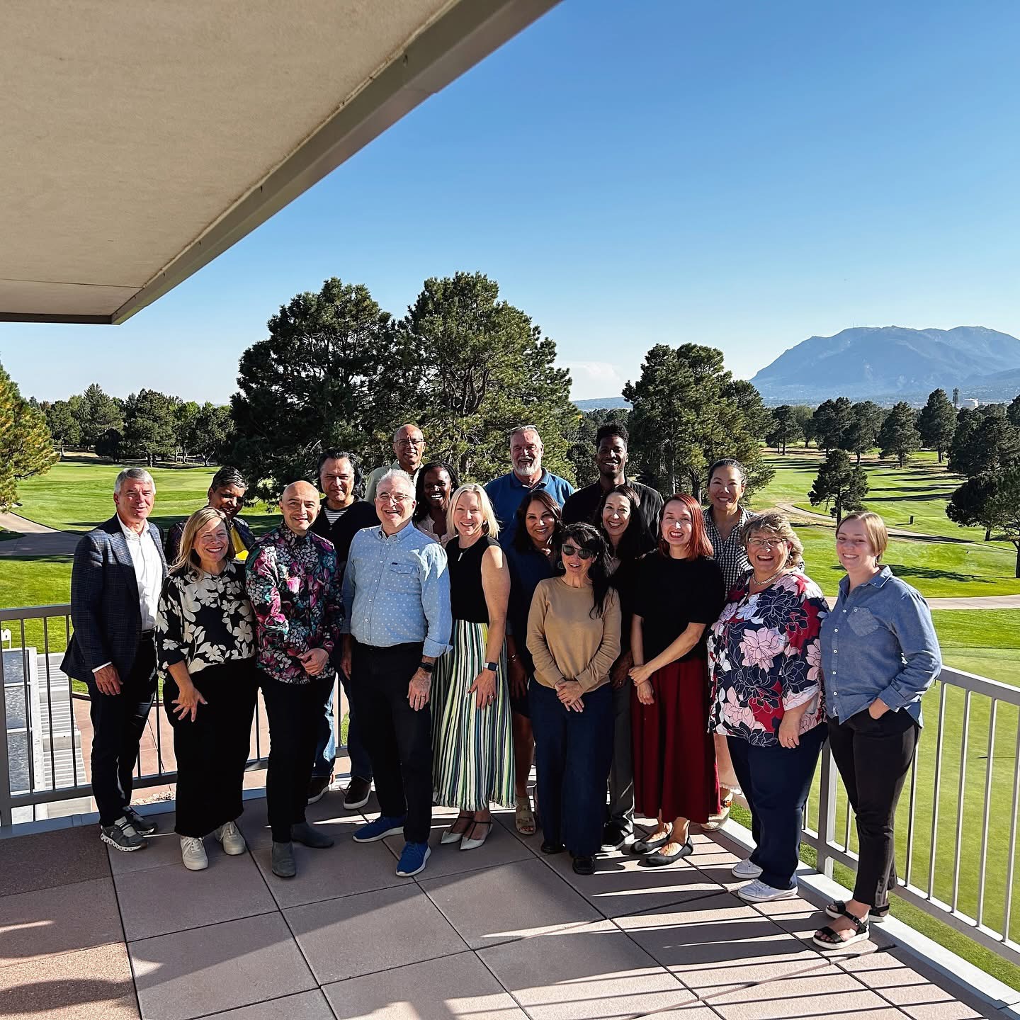 BSF Staff & Board at a Board Retreat in 2024, a golf course in the background as they pose for the photo on a decks