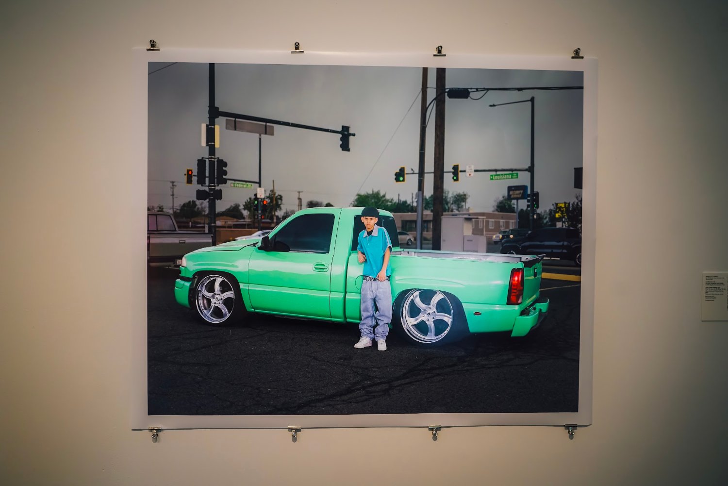 A framed photograph of a green lowrider truck, on view at MCA Denver