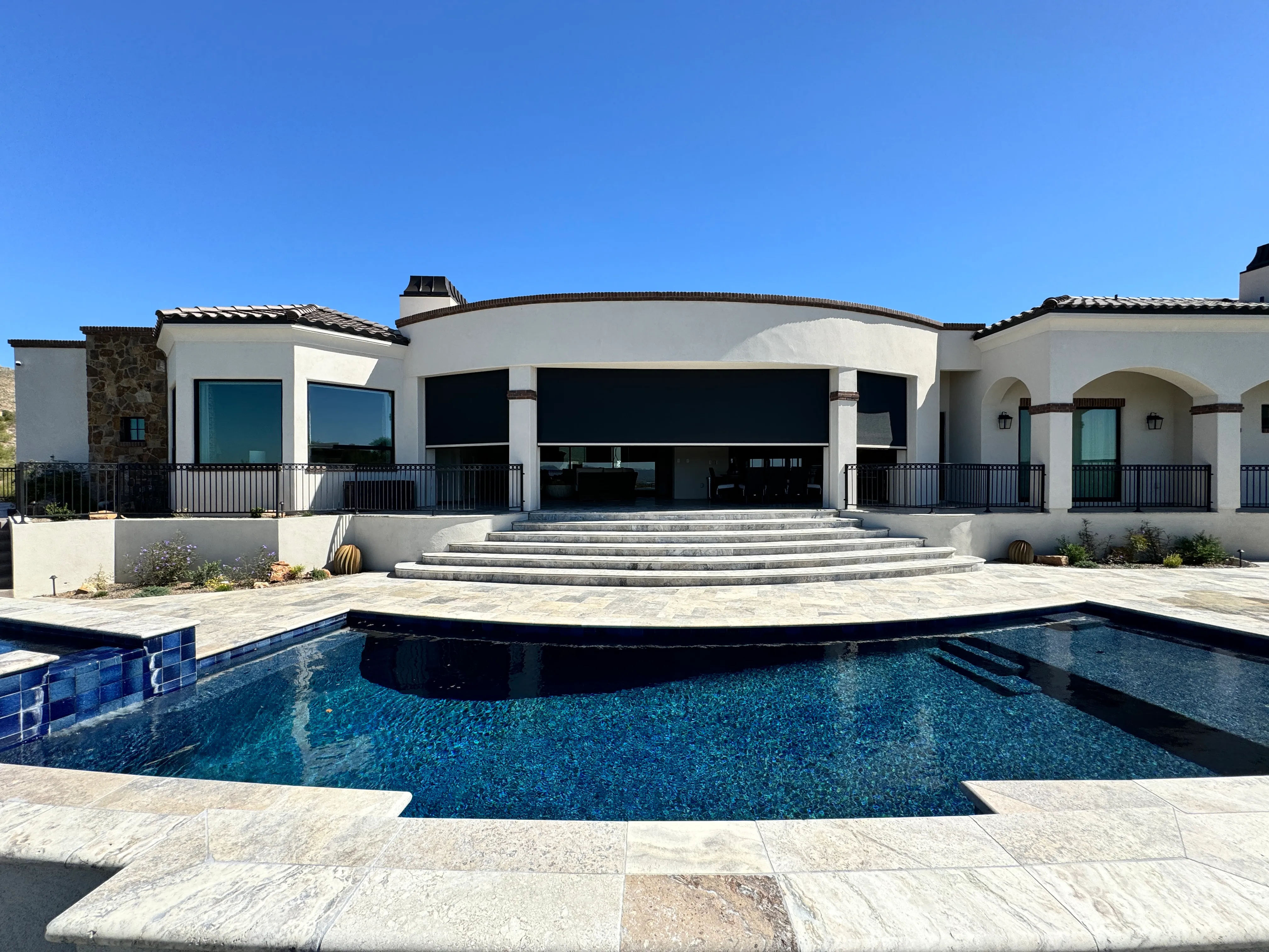 Modern house with large black patio screens and pool.
