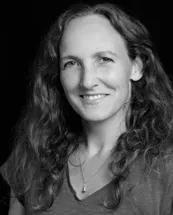 Leende kvinna med lockigt hår i svartvitt porträtt