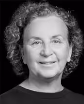 Svartvitt porträtt av en leende äldre kvinna med lockigt hår