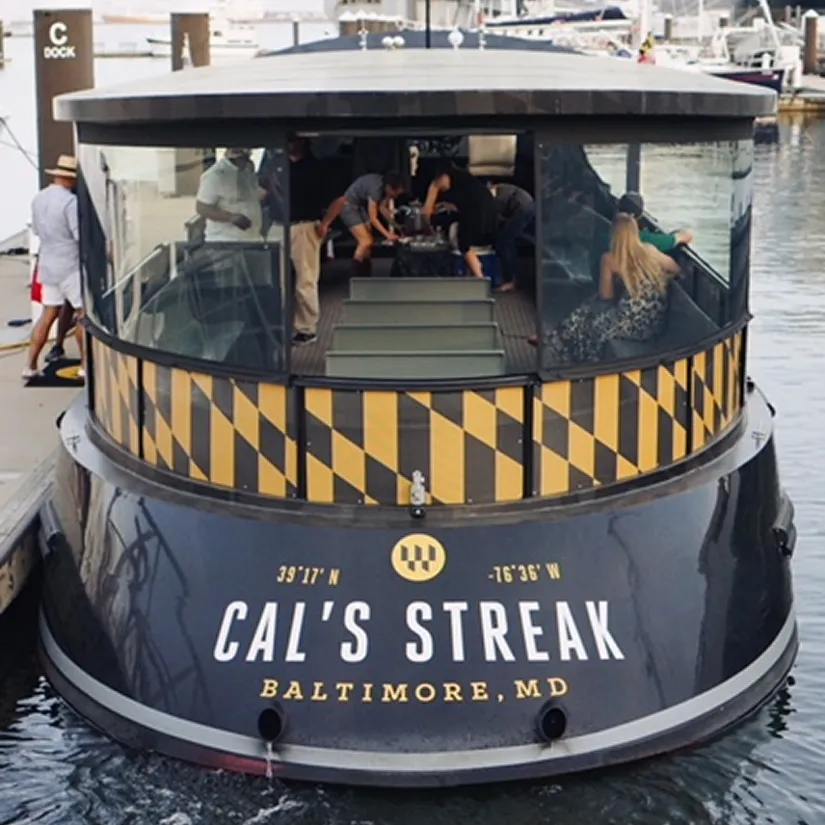 A black and yellow boat docked at a dock.