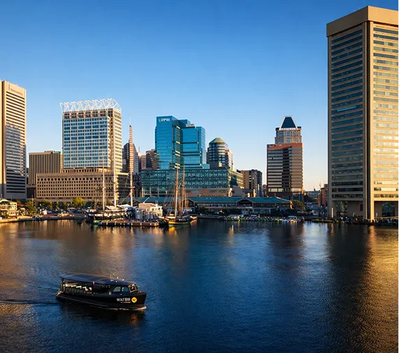 A boat is in the water in front of a city.