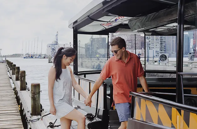 A man and a woman holding hands on a boat.